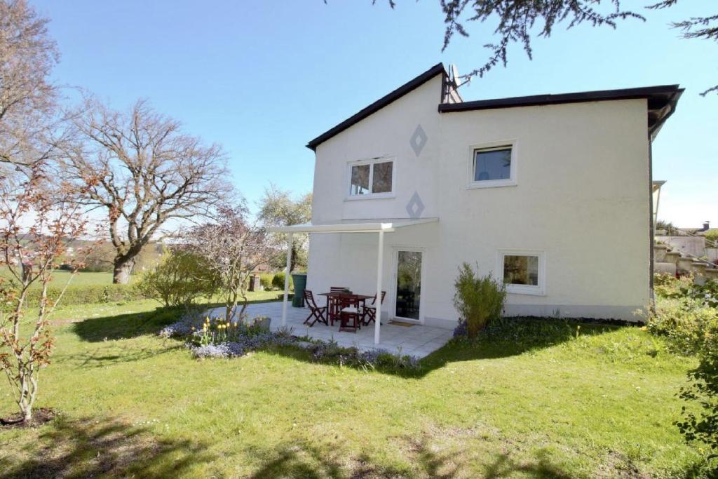 a white house with a patio in a yard at Ferienwohnung No15 in Pfullendorf