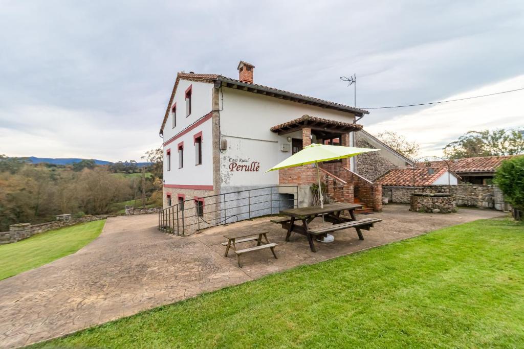 a picnic table in front of a building at Casa Rural Perullé in San Vicente de la Barquera