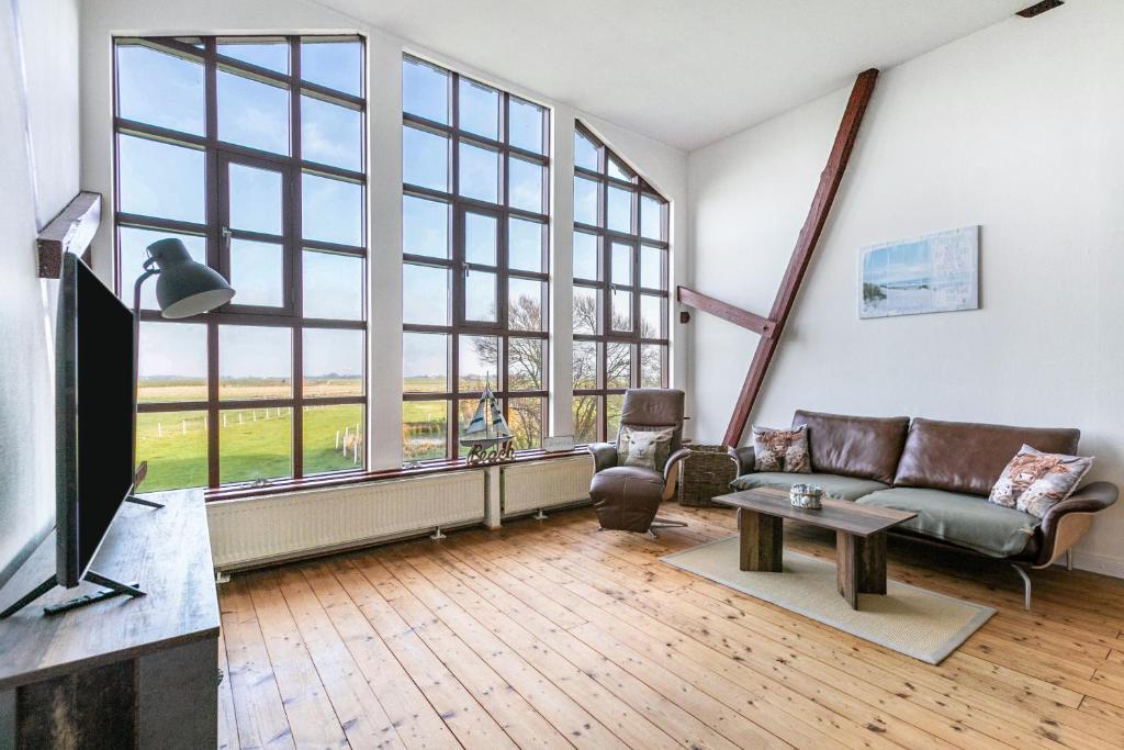 a living room with a couch and a large window at Wat'n Utkiek in Rodenäs
