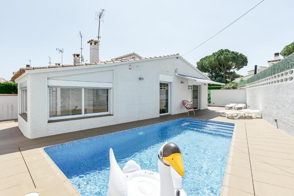 a house with a swimming pool with two swans in it at Villa La Vall in L'Escala