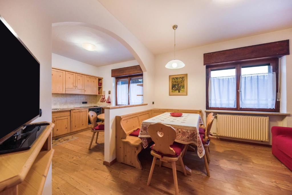 a kitchen and dining room with a table and chairs at La pratolina piano terra in Castello di Fiemme