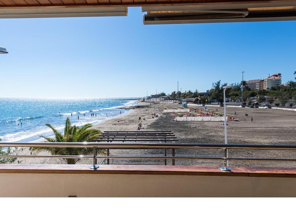 a view of the beach from a balcony of a beach at Chalet en la playa San Agustin in Maspalomas
