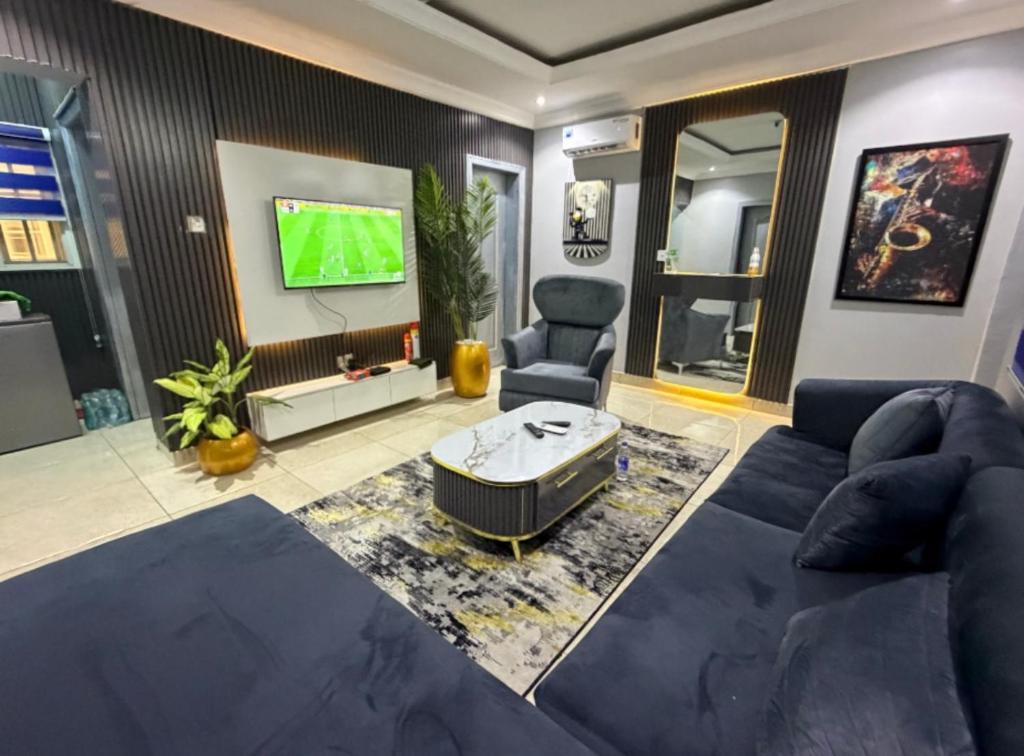 a living room with a couch and a tv at Max Court in Ikeja