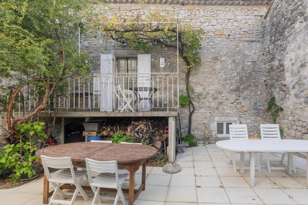 a patio with a table and chairs and a balcony at Chez l'Oncle in Gras
