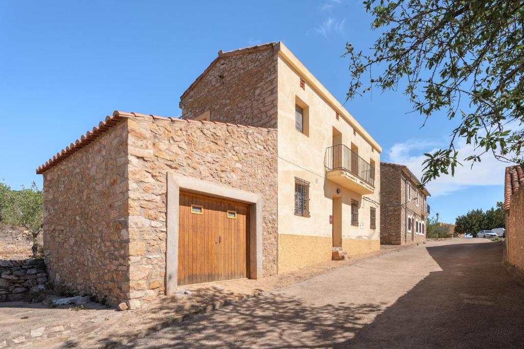 a brick building with a wooden door on a street at Casa del Practicant in Culla
