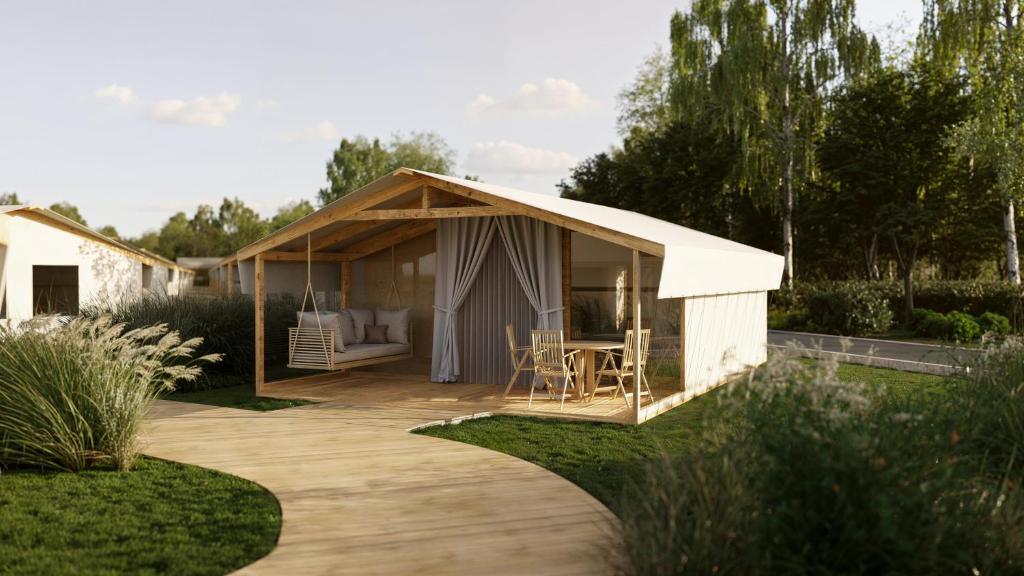 a small white shed with a patio in a garden at Eco Camping in Spytkowice