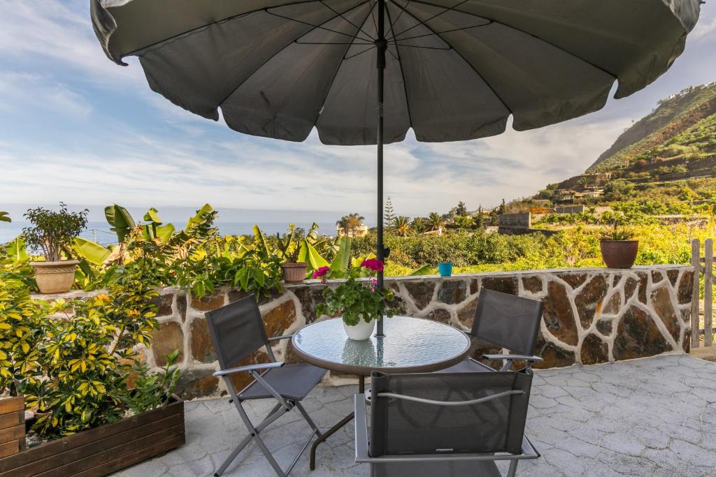a patio with a table and chairs and an umbrella at Vista Valle in La Orotava
