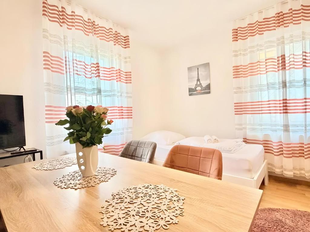 a room with a table with a vase of flowers on it at Ferienwohnung mit Parkmöglichkeit in Göppingen