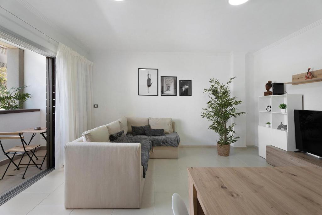 a white living room with a couch and a tv at Apartamento Opuntia in La Orotava