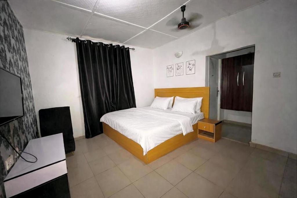 a bedroom with a bed and a television in it at Elite Hotel in Ekpoma