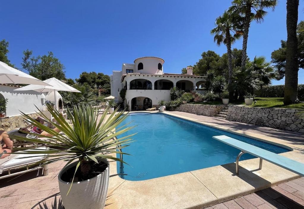 a house with a swimming pool in front of it at Villa Torre in Jávea