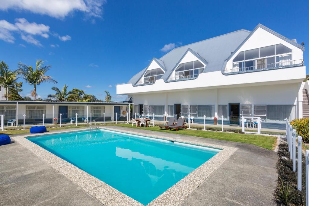 a house with a swimming pool in front of it at Aloha Seaview Resort Motel in Paihia