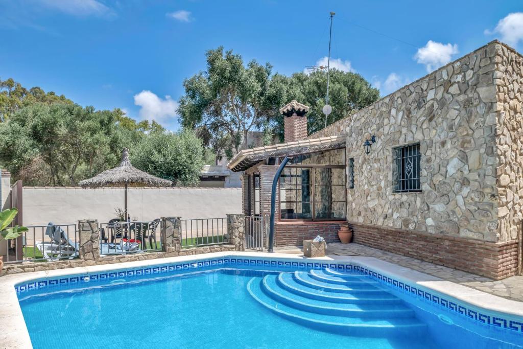 a house with a swimming pool in front of a building at Casas al Alba in Zahora