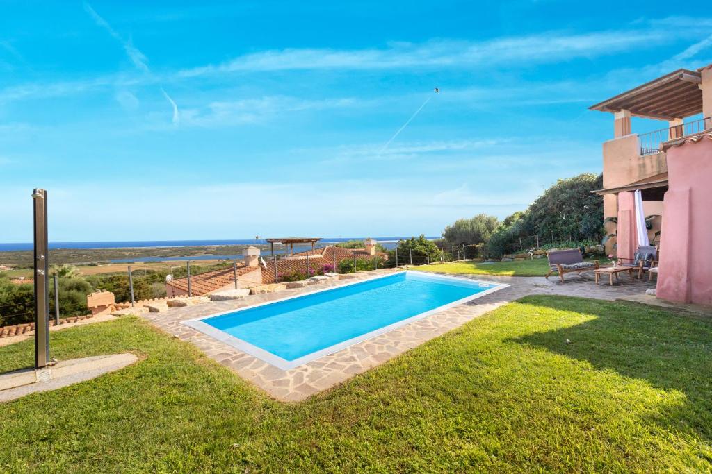 a swimming pool in the yard of a house at Villa Sa Pintadera private pool in Stintino