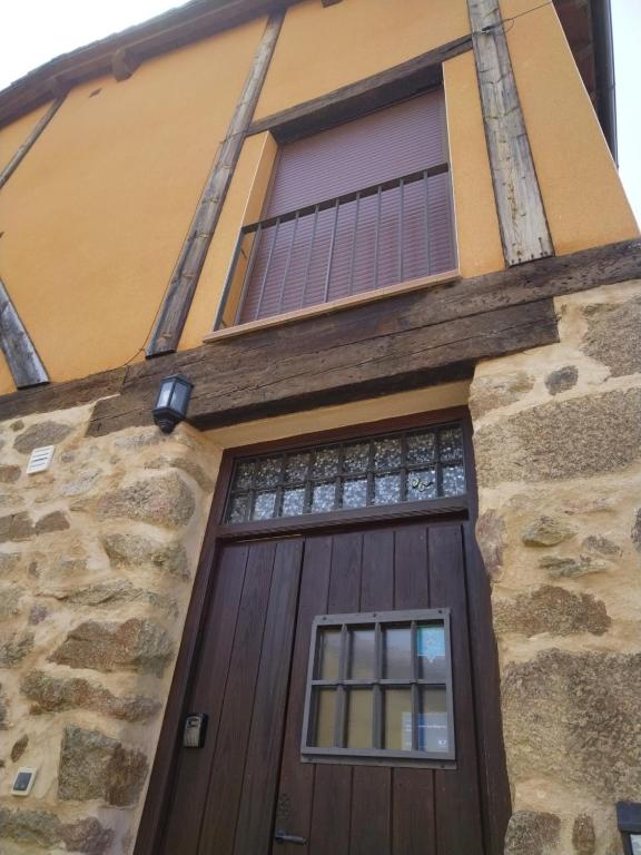 a wooden door on a stone building with a window at Más Quimera in Gilgarcía