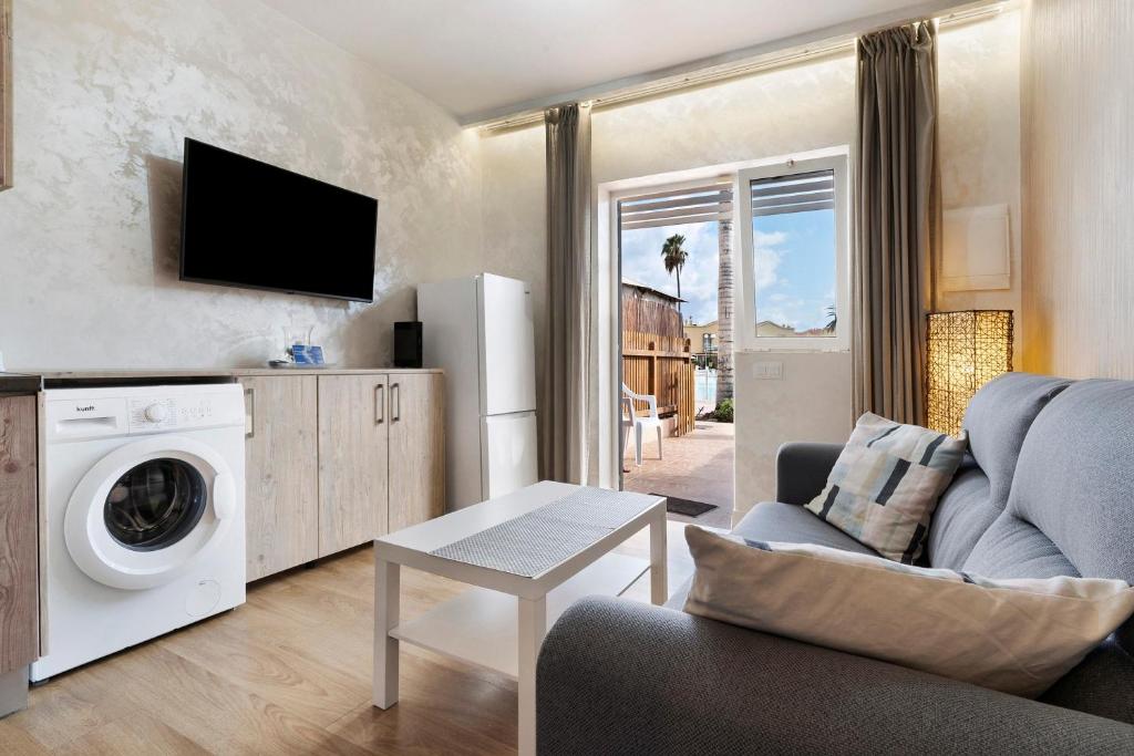 a living room with a washing machine and a couch at Bungalow Green Oasis in San Bartolomé