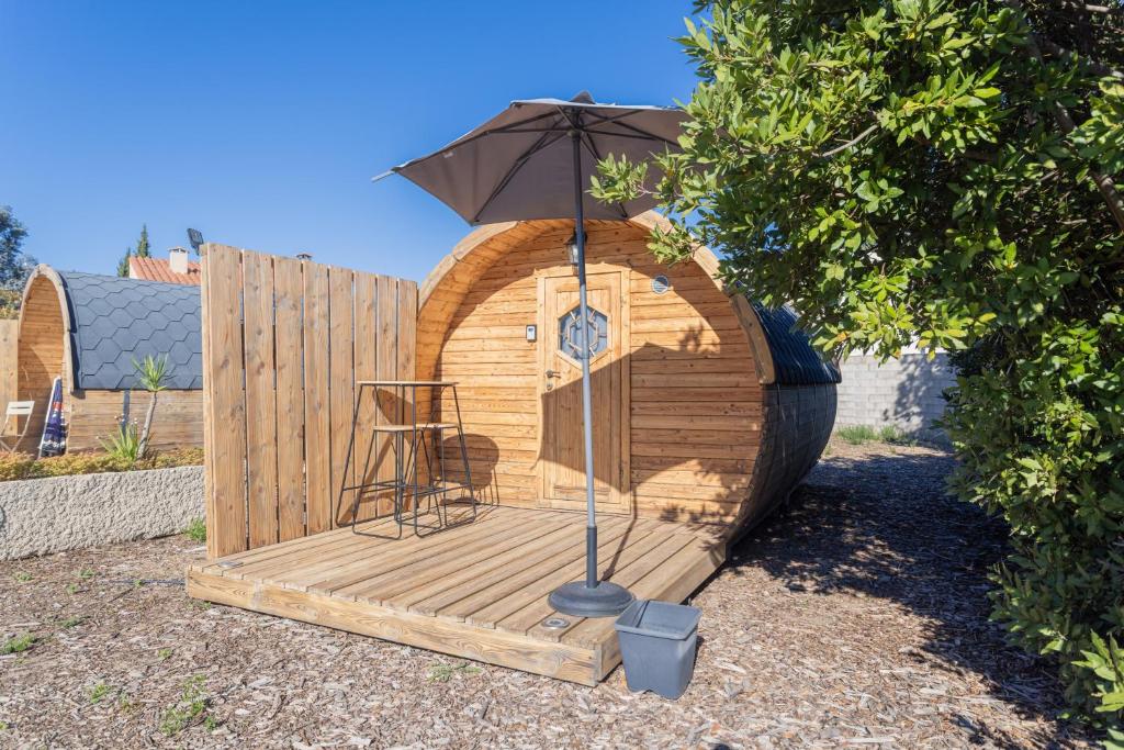 a wooden deck with an umbrella and a chair on it at Barrel Orange in Saint-André