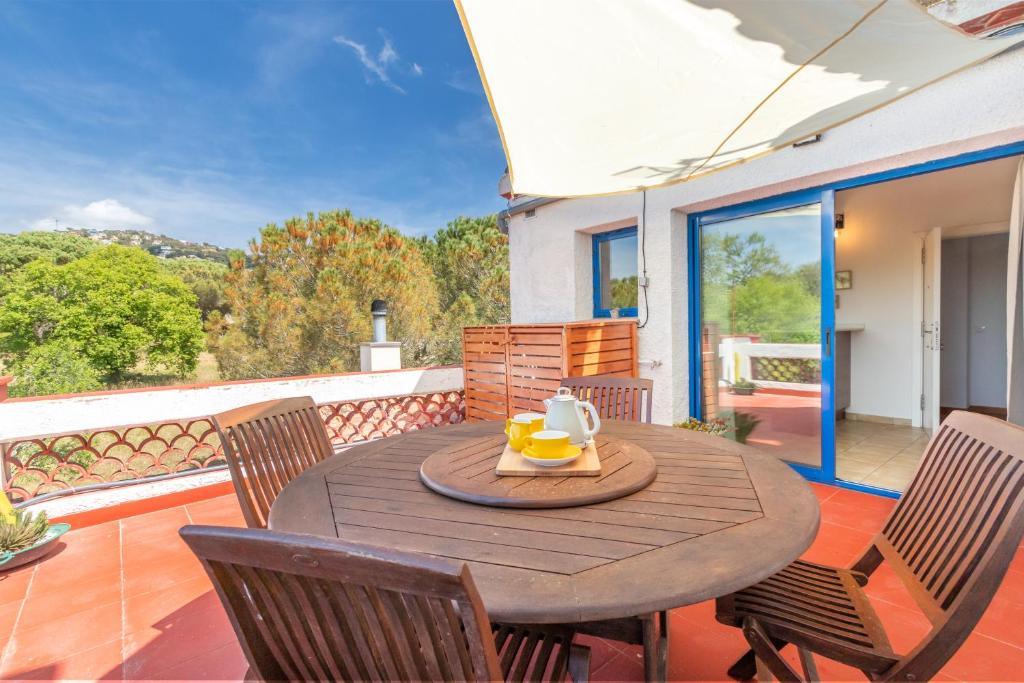 a wooden table and chairs on a balcony with a table and chairs at Mas Tinus - Palmera in Santa Cristina d'Aro