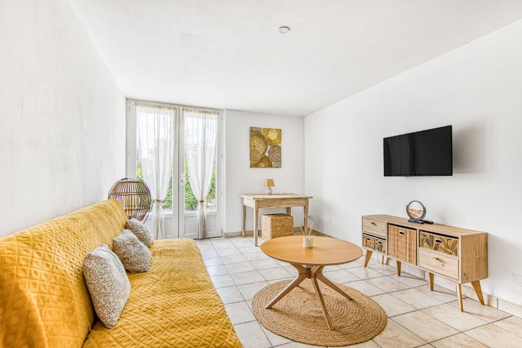 a living room with a couch and a tv at Gite Barrail du Moulin in Bégadan