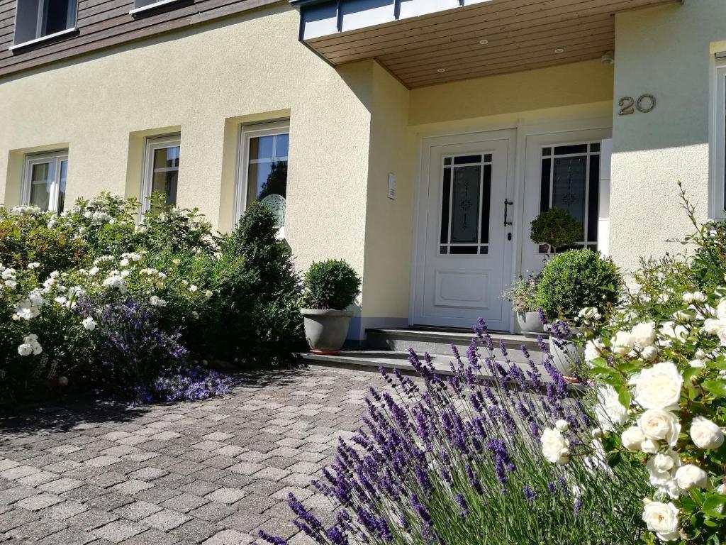 a house with a white door and some flowers at Ferienwohnungen Ambiente-Schmidt in Olsberg