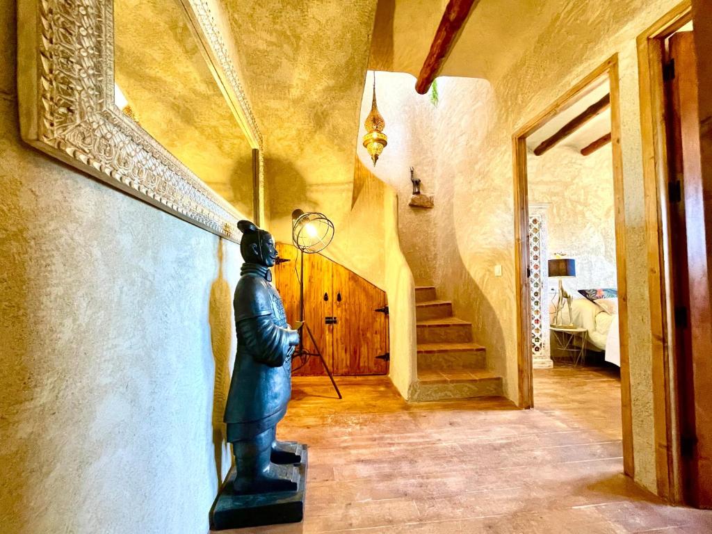 a statue of a man in a hallway with a staircase at El Kubo in Olba