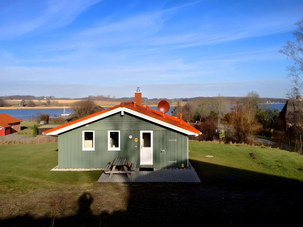 a small green house with an orange roof at Skipper-Lodge Nord in Kosel