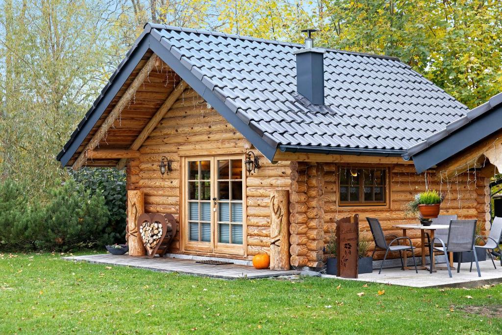 a log cabin with a table and chairs at Chalet am See - Vogtland Chalet in Bad Brambach