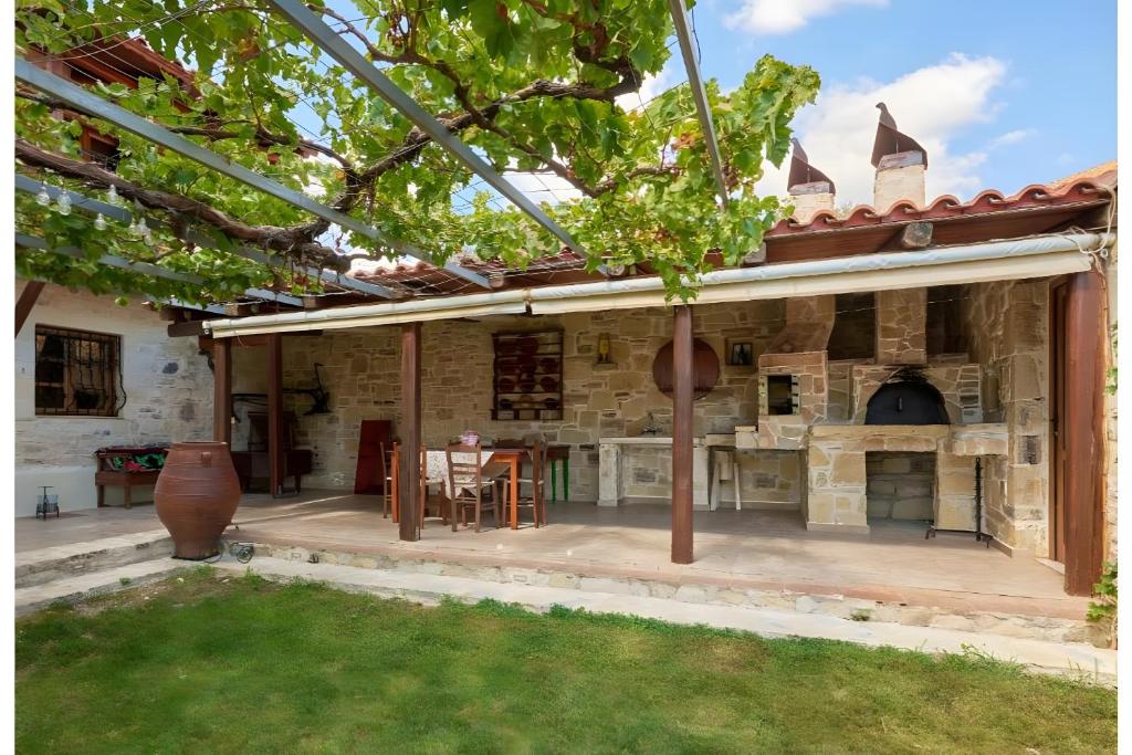 an outdoor patio with a table and a fireplace at Apartment Vergina in Áyioi Dhéka