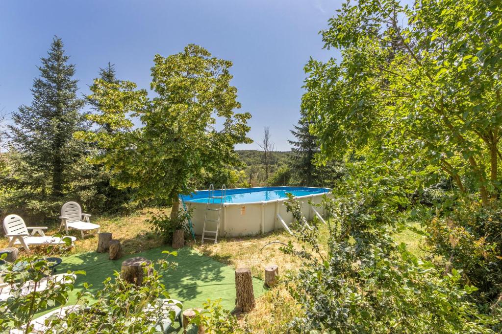 a pool in the middle of a yard with trees at El Torrent in Pinell de Solsones