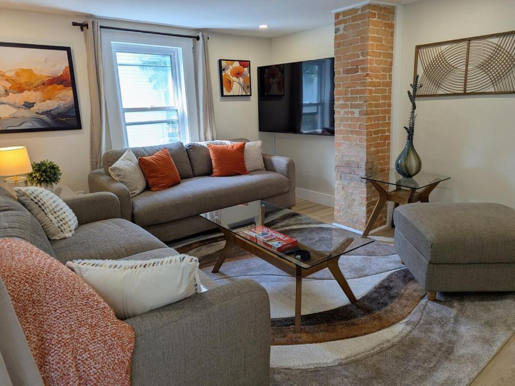 a living room with two couches and a table at Modern Comfort in Marlborough