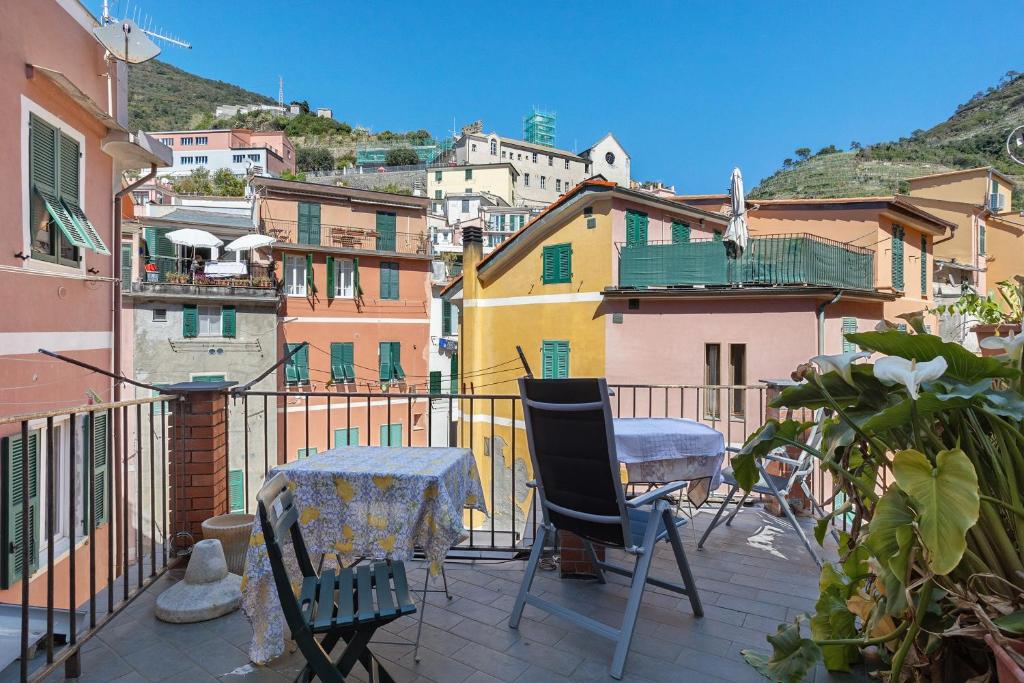 a balcony with a table and chairs and buildings at Lisettarooms in Vernazza