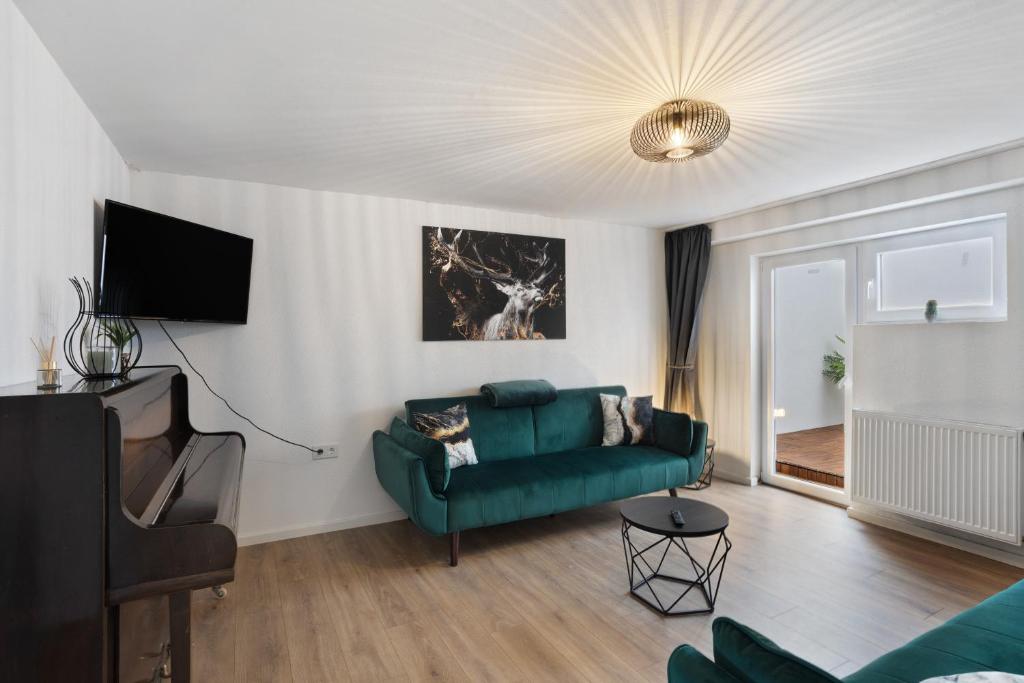 a living room with a green couch and a television at Fewo Kerbe in Willingen