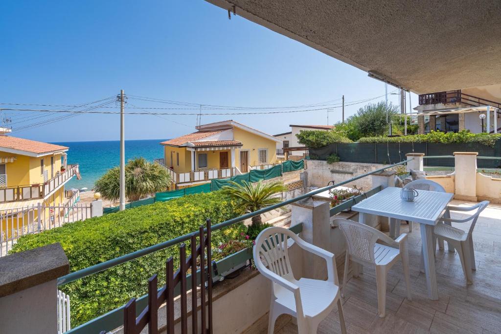 a balcony with a table and chairs and the ocean at Villa Clara in Gallina