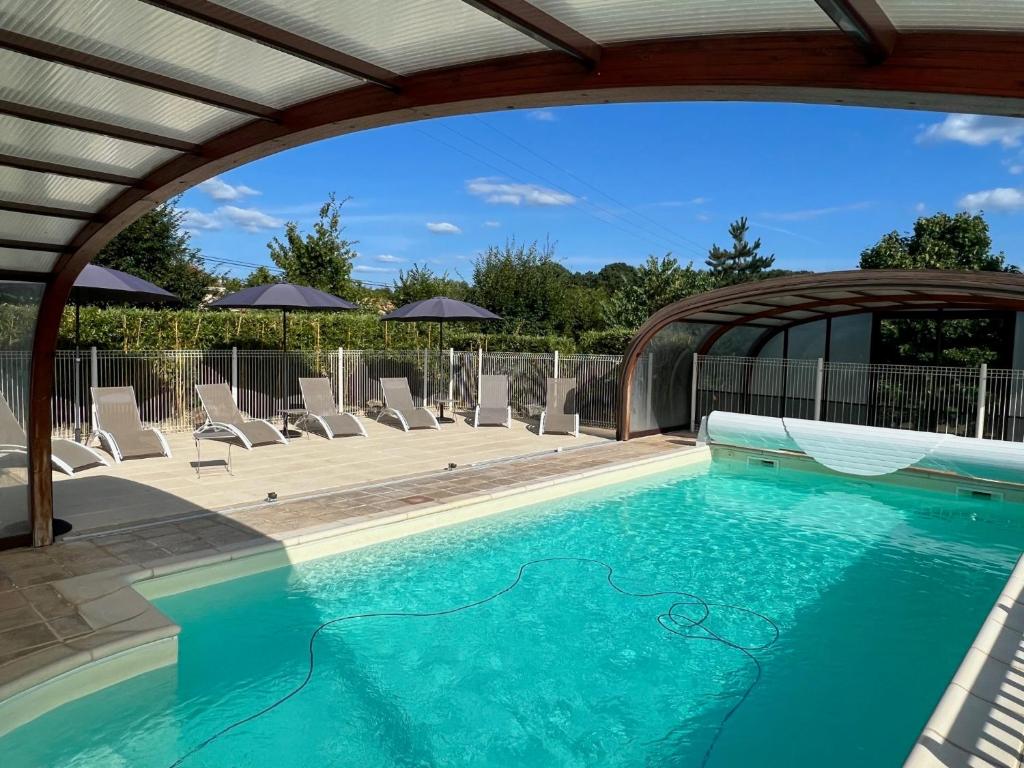 a swimming pool with chairs and an arborivatingivating at Maison Iris in Castelnaud La Chapelle