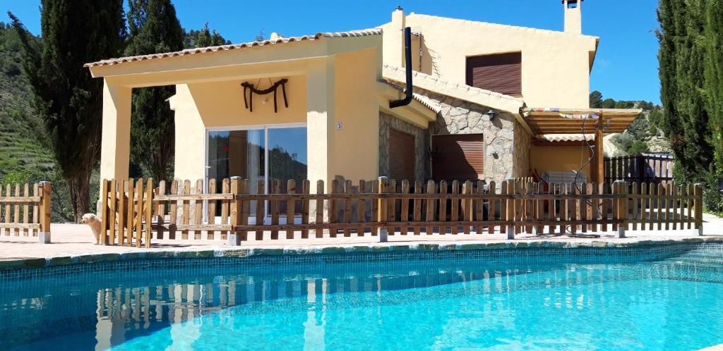 a villa with a swimming pool in front of a house at Cortijo la Era in Castril