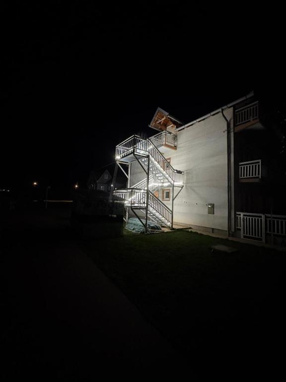 a building with a staircase on the side of it at night at Bugojno Avantura in Donjići