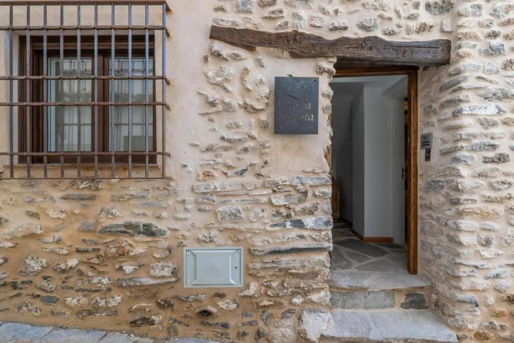 an entrance to a stone building with a window at Cueva Secreta Güejar in Güéjar-Sierra