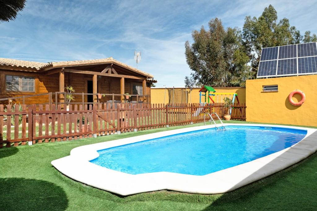 a swimming pool in a yard next to a house at Casa rural la cabaña in Vejer de la Frontera