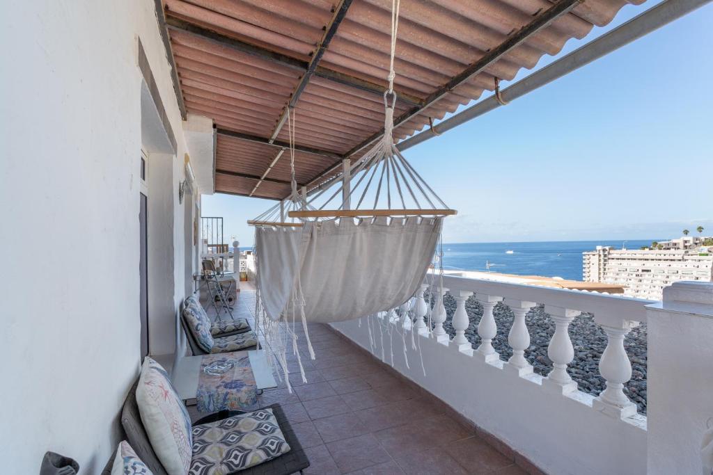 a balcony with a hammock and a view of the ocean at Welcome To The Relax Zone in Los Caideros