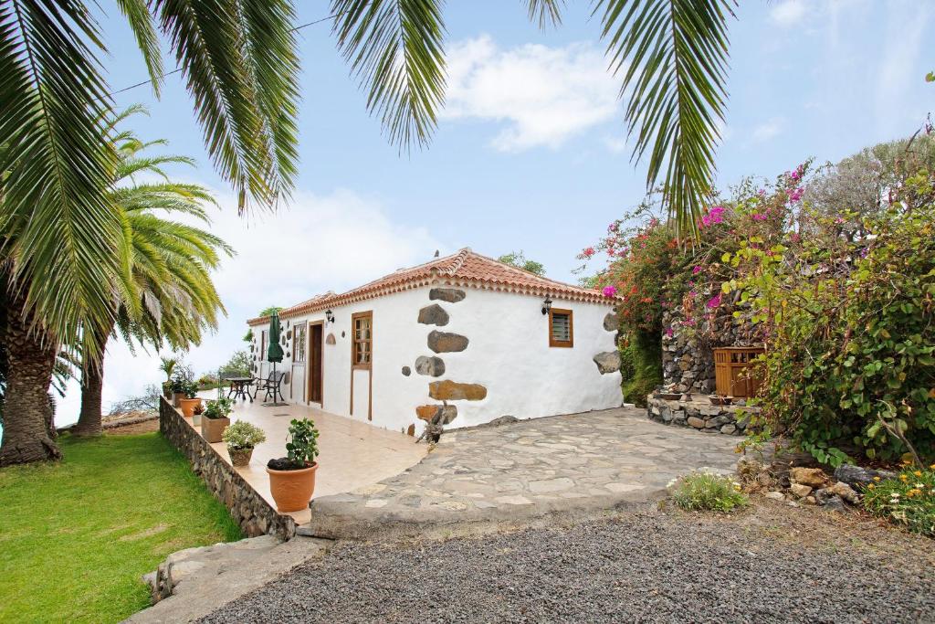 a white house with a palm tree and a yard at Casa Rural Ciso in Tijarafe