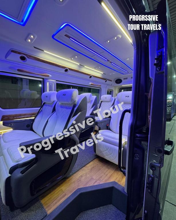 a bus with white seats in a room at Ultra Premium Camper Van in New Delhi