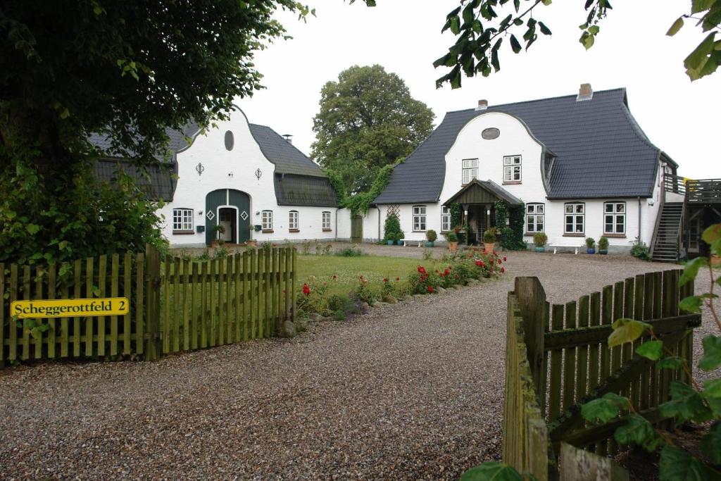 a fence in front of a white house at Ferien Auf Dem Lande in Scheggerott