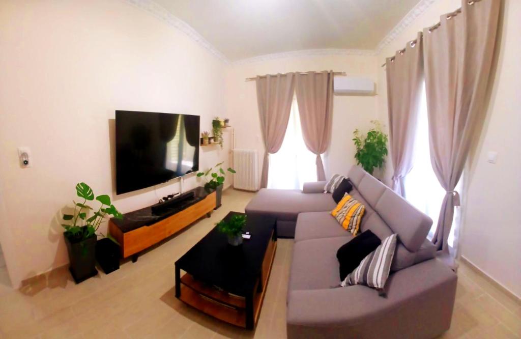 a living room with a couch and a flat screen tv at Ηome & Garden with parking close to Olympic Stadium in Athens