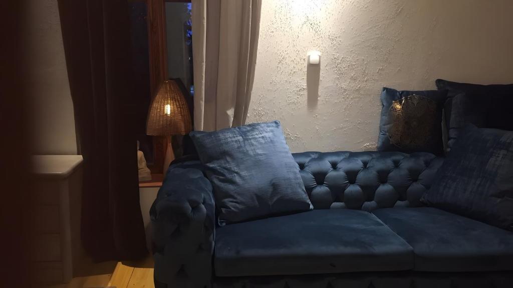 a blue couch in a living room with a lamp at Gemütliches Refugium im Klosterdorf in Neustadt am Rübenberge