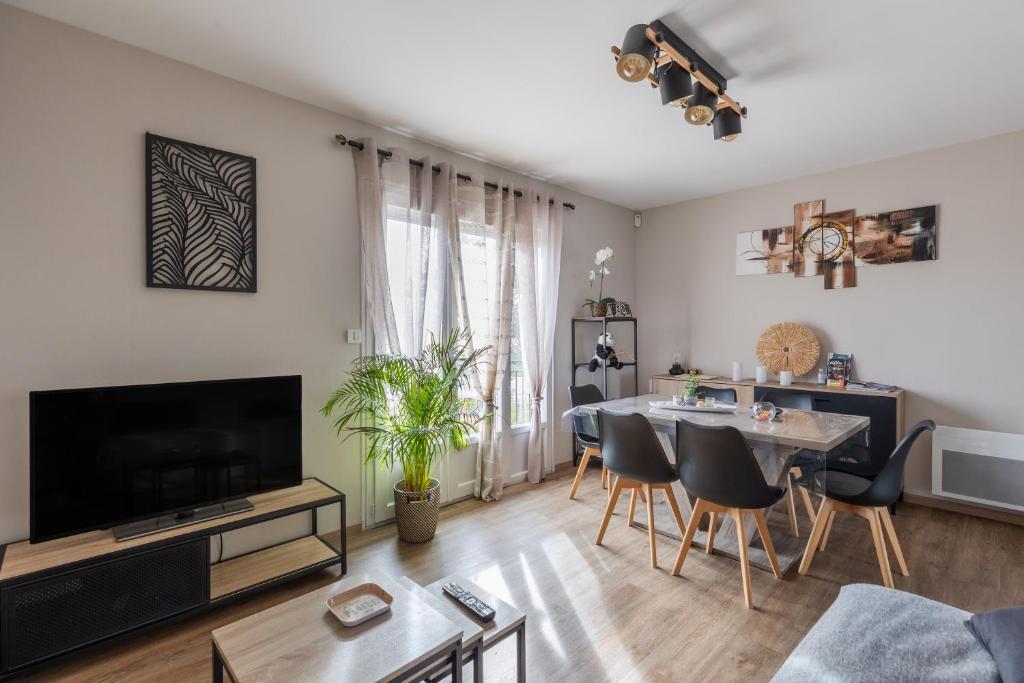 a living room with a television and a dining room at Gite Du Ptit Lou in Noyers-sur-Cher