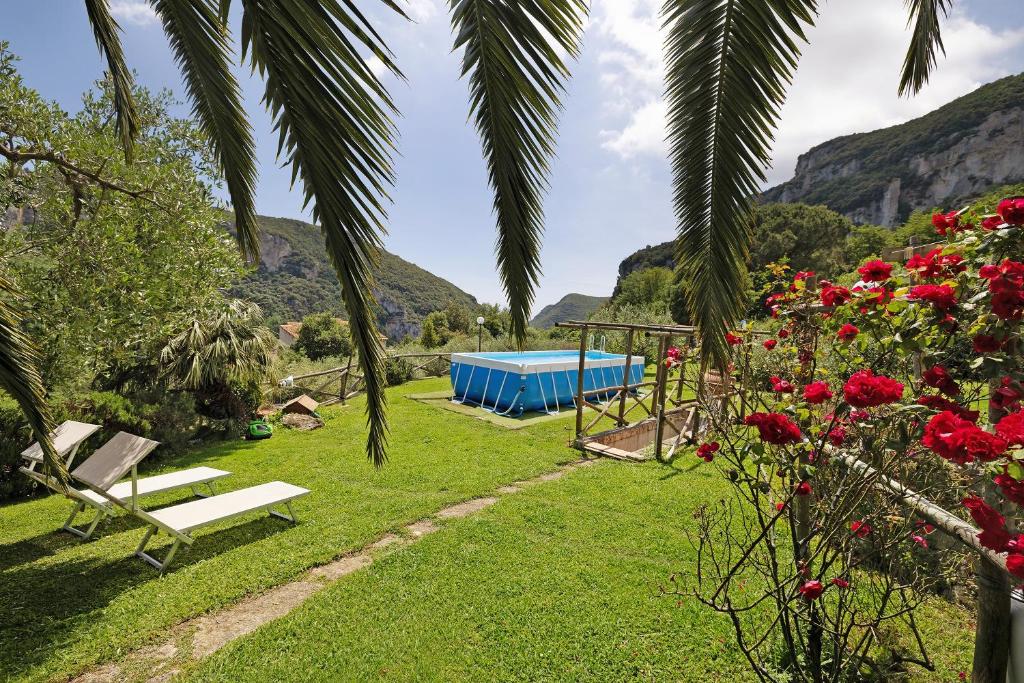 a garden with a picnic table and a blue tent at Casa Virginia - Corbezzolo in Orco Feglino