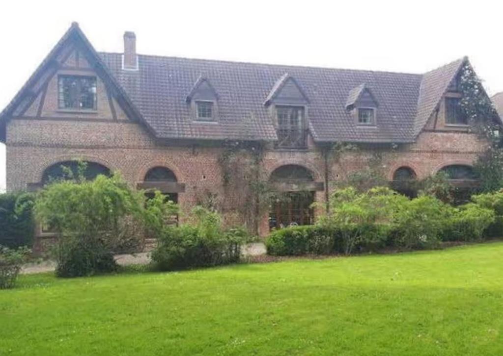 a large brick house with a green lawn in front of it at Le Relais de Chasse in Eu