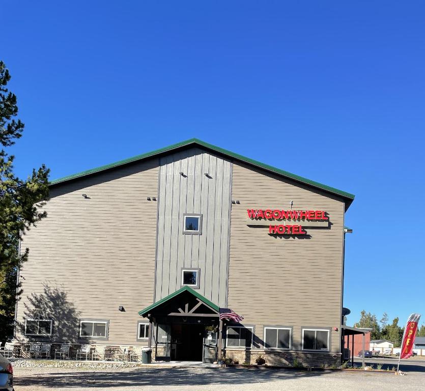 a large white barn with a red sign on it at Wagon Wheel Yellowstone in West Yellowstone