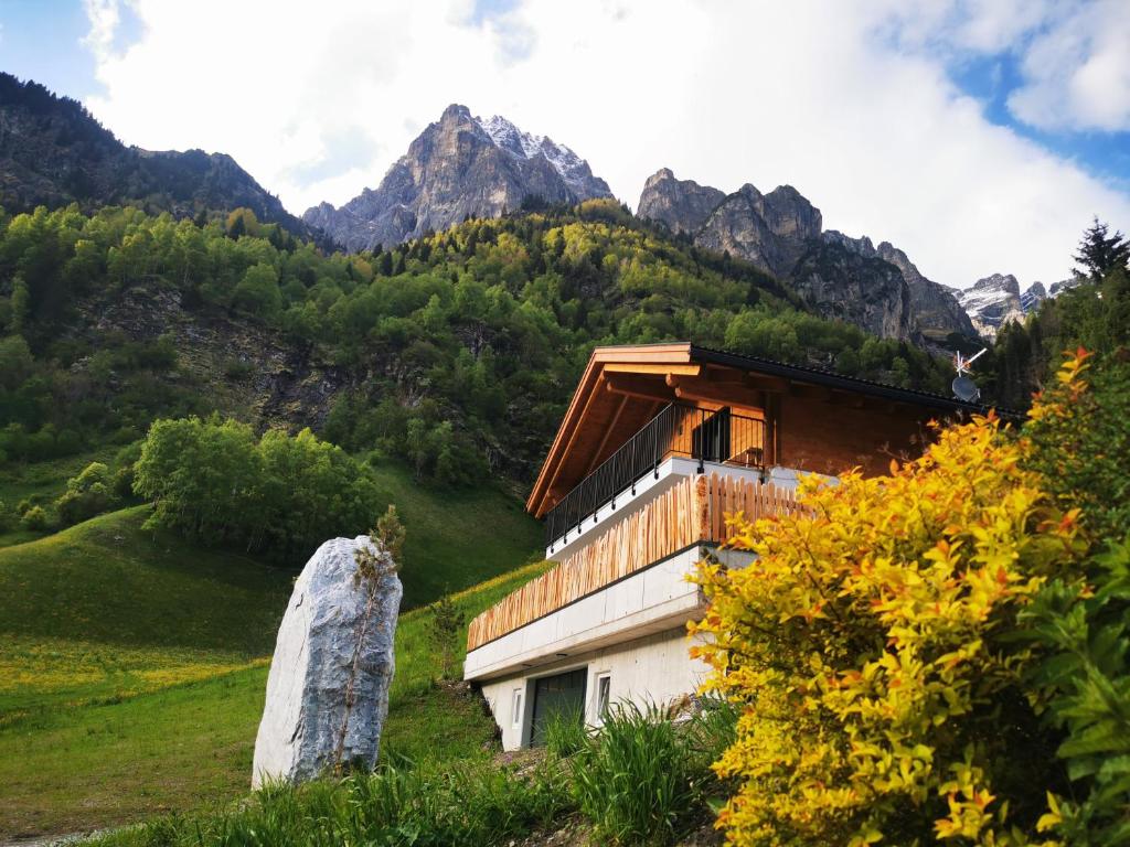 a building on a hill with mountains in the background at Mountain Chalet Tribulaun Pflersch in Colle Isarco