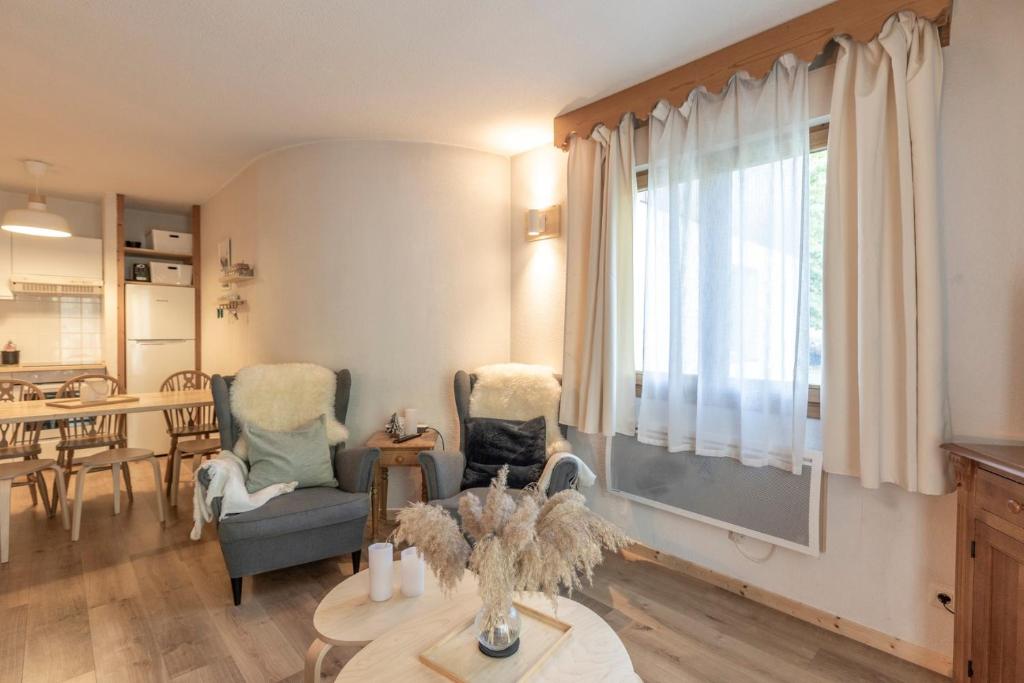 a living room with two chairs and a table at Appartement à Samoëns – 6 couchages in Samoëns